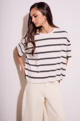 Remera de algodón color crudo con rayas horizontales negras, corte holgado y mangas cortas.