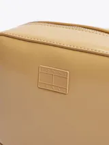 Bandolera Tommy Jeans Essential rectangular color beige, con acabado brillante y logo de la marca en relieve en el frente.