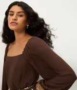 Vestido midi de viscosa con estampado de follaje, escote cuadrado y mangas largas con puños elásticos. Presenta un corte evasé y un lazo fino en la cintura.