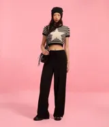 Pantalón flare negro con textura acanalada, cintura elástica con lazo y confeccionado con viscosa certificada.