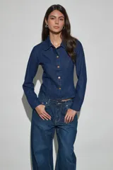 Campera corta de denim azul oscuro con cuello camisero, mangas largas y cierre frontal de botones metálicos dorados.