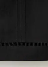 Top negro de corte recto y diseño corto, con escote recto, tirantes finos y detalles de costuras verticales con inserción semitransparente.