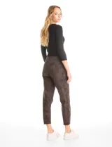 Pantalón de corte crop, color gris, con diseño de cinco bolsillos, cierre frontal con botón y ruedo irregular con terminación desflecada.