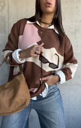 Sweater de punto con diseño de bloques de color en tonos chocolate, rosa y beige, de corte oversize y cuello redondo.