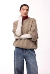 Sweater de tejido de punto grueso con silueta amplia y mangas 3/4. Presenta cuello redondo y un calce relajado.