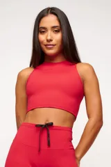 Top deportivo rojo de diseño cerrado y estructurado, con protección UV50+.