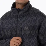 Campera polar con cierre frontal completo, confeccionada en tejido exterior tipo punto con estampado geométrico. Cuenta con cuello alto, bolsillos laterales y un bolsillo frontal con cierre en el pecho, además de un parche con logo de la marca.