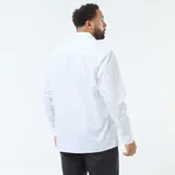 Camisa de manga larga con corte regular fit, color blanco con estampado de pequeños puntos negros. Presenta cuello clásico y cierre frontal con botones.