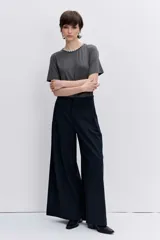 Remera de algodón color gris oscuro, con cuello redondo adornado con pedrería brillante, manga corta y corte recto.