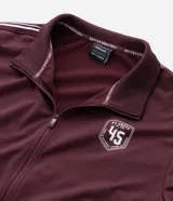 Saco deportivo Get Over de cuello alto con cierre frontal por cremallera. Presenta diseño en color bordó con rayas laterales contrastantes en los hombros y mangas, puños y bajo con acabado en rib, y estampa localizada en el pecho.