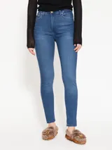 Jeans chupín de tiro medio, color azul, súper elastizado y largo hasta el tobillo.