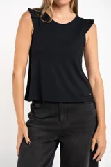 Remera negra de viscosa y elastano, con cuello redondo y mangas cortas con volados. Tiene un corte holgado y un pequeño detalle metálico dorado en el bajo.