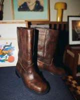 Bota de cuero vacuno color marrón oscuro, de caña media y taco bajo.