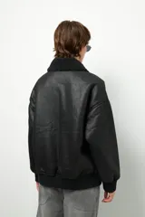 Campera gamulán marrón con interior de corderito sintético color crema, cierre frontal con cremallera, dos bolsillos laterales con solapa y puños elastizados.