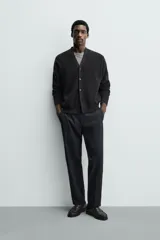 Pantalón de vestir regular fit color negro, confeccionado en tejido con mezcla de lana y elasticidad. Cuenta con cintura elástica, bolsillos frontales, bolsillos traseros de vivo con botón, y cierre frontal con cremallera y botón.