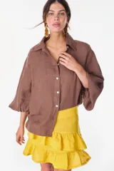Camisa de lino italiano con estampado a rayas verticales irregulares, de corte holgado, cuello clásico, mangas abullonadas y cierre frontal con botones.