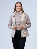 Chaleco capitoneado color rosa claro, con cuello alto, cierre frontal y bolsillos laterales.