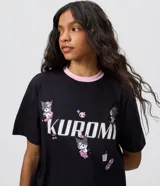 Remera de algodón negra con cuello redondo rosado en contraste y mangas cortas. Presenta un diseño estampado en el frente con la leyenda 'Kuromi' e ilustraciones del personaje en estilo skater.