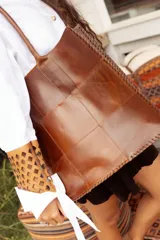 Bolso tote grande de cuero natural en color marrón, con diseño de piezas unidas mediante costuras visibles y asas de hombro.