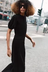 Top de algodón color negro con cuello redondo y mangas cortas abullonadas con terminación elástica.