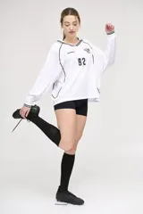 Camiseta blanca de manga larga con cuello en V y detalles en negro. Presenta el logo de la marca en el pecho, el número 92 y un escudo con tres balones de fútbol.