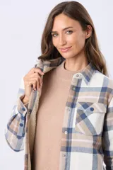 Campera de viyela a cuadros en tonos blanco, azul y tostado, forrada en corderito en su interior. Cuenta con cierre frontal de botones, bolsillos en el pecho con solapa y bolsillos laterales.