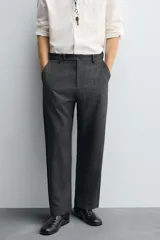 Pantalón de corte carrot fit confeccionado en tejido con mezcla de viscosa. Presenta bolsillos frontales, bolsillos traseros de vivo y cierre frontal con cremallera y botones.