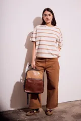 Remera de algodón color crudo con rayas horizontales color café, de corte oversize y mangas cortas.