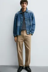 Pantalón chino de corte recto confeccionado en tejido ligero de algodón con estructura canvas. Presenta bolsillos frontales, bolsillos traseros de vivo y cierre frontal con cremallera y botón.