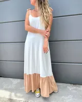 Vestido largo blanco con volado color beige en el ruedo y breteles finos con lazos en los hombros.