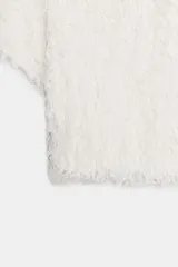Top de punto texturizado con acabado de flecos, cuello barco y mangas cortas.