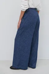 Pantalón de corte ancho y tiro alto, confeccionado en tejido con textura tipo espiga en color azul. Presenta pinzas en la cintura y costuras reforzadas.