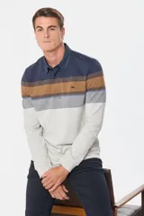 Remera tipo polo de manga larga con diseño de rayas horizontales en tonos azul marino, marrón, gris y blanco. Presenta cuello de tela tipo denim y cierre frontal con botones ocultos.