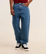 Pantalon de jean gris con lavado deslavado, de corte baggy y silueta holgada. Cuenta con bolsillos al frente y atras, y cierre de boton y cremallera.