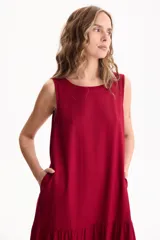 Vestido largo negro de lino, sin mangas, con escote redondo y diseño fluido con volados escalonados en la falda.