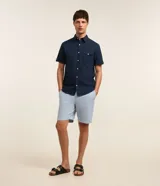 Bermuda slim de lino y algodón color beige, de corte ajustado, con trabillas para cinturón y bolsillos laterales y traseros.