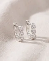Caravanas tipo argolla pequeña de plata 925, con diseño lineal adornado con tres circonias engastadas.