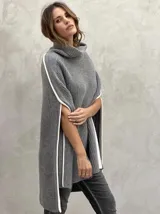 Poncho gris de lana con cuello alto y aberturas laterales con ribete blanco.
