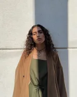 Collar ajustable con dije de aro irregular plateado, suspendido de un cordón negro de algodón natural.