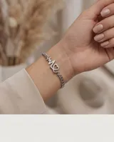 Pulsera de acero plateada con cadena eslabonada y dije central que combina un electrocardiograma con la palabra mamá y un corazón.