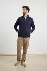 Cardigan de tejido de punto color verde militar, con cierre frontal de metal y cuello redondo. Presenta detalle de tejido plano en la cartera del cierre y en los bolsillos laterales.