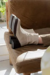 Botas de caña corta en gamuza color beige, con plataforma y taco cuadrado de madera oscura. Presentan cierre lateral interno.