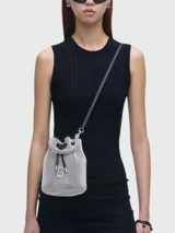 Cartera tipo bucket mini, color negro con apliques de strass, asa corta superior y correa larga desmontable. Incluye cierre con cordón ajustable y logo "J Marc" metálico en el frente.