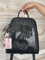 Mochila negra de cuero natural con detalles en charol y correa con la palabra "CHARB".