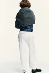 Pantalón de felpa de tiro alto con cintura elástica y corte recto. Cuenta con bolsillos laterales ocultos en la costura y bajo ajustable con cordón elástico y stoppers.