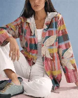 Campera impermeable con capucha y cordón ajustable, con diseño estampado a cuadros multicolor y hojas grandes. Cuenta con cierre frontal de botones y bolsillos laterales.