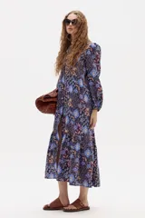 Vestido midi de lino con estampado floral, cuello mao, mangas largas con puños elásticos y corte holgado con frunce en el ruedo.