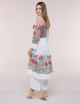 Cardigan tipo kimono largo de tul blanco semitransparente, con frente abierto y mangas largas. Presenta vistosos bordados florales multicolor en mangas, dobladillo y laterales.