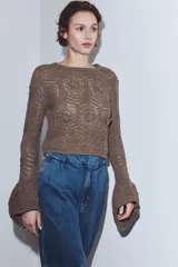 Pantalón de jean estilo bombacho con tiro medio, confeccionado en denim azul con costuras verticales decorativas y puños ajustados en el ruedo.
