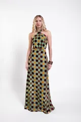 Vestido largo de tul con estampado de cuadrados de terciopelo multicolor, con escote halter cruzado y aberturas laterales en la cintura.